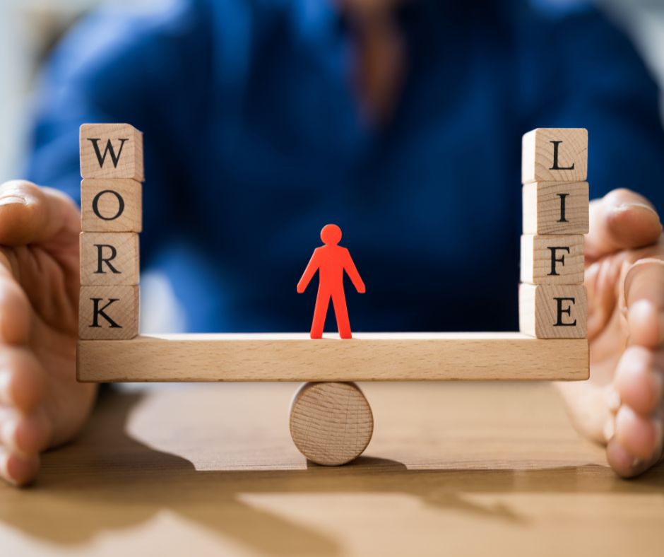 Miniature of a person standing between wooden blocks spelling the words work and life